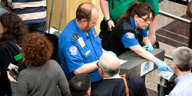 FILE: REUTERS: UNDATED: Transportation Security Administration employees check passenger IDs before they enter security screening at Reagan National Airport, outside Washington, D.C.
