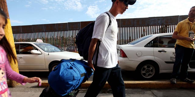 NOGALES, MEXICO - JULY 7:  A mexican national carts his luggage towards the U.S-Mexico border on July 7, 2012 in Nogales, Mexico. The president-elect of Mexico, Enrique PeÃ±a Nieto, stated that he wants to expand his country's drug-war partnership with the United States but that he would not support the presence of armed American agents in Mexico.  (Photo by Sandy Huffaker/Getty Images)