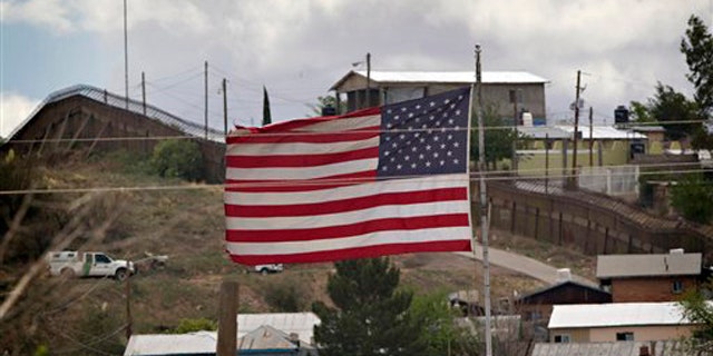 In this April 22 photo, the American flag flies along the international border in Nogales, Ariz. (AP Photo)
