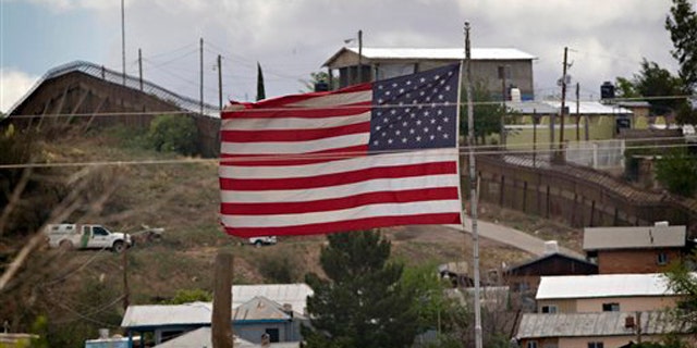 In this April 22 photo, the American flag flies along the international border in Nogales, Ariz. (AP Photo)