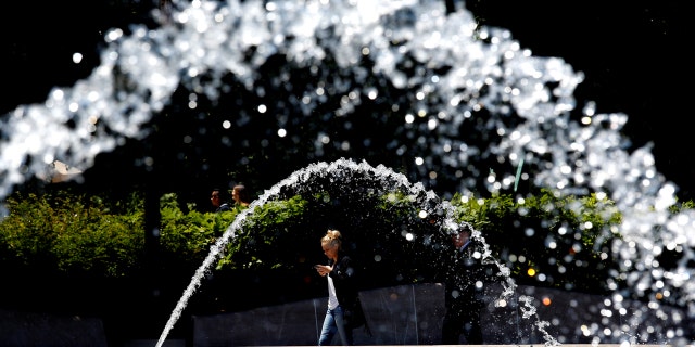 A woman walks by a fountain in the National Gallery of Art Sculpture Garden on a much welcomed sunny day in Washington May 16, 2016.