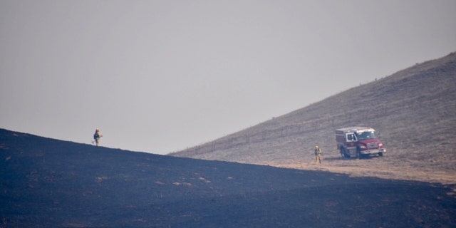 Firefighters respond to charred areas from wildfires in Northern California.