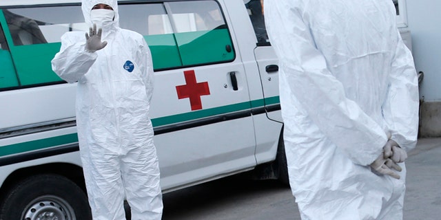 Oct. 27, 2014: This photo shows medical personnel in protective suits standing by an ambulance, at the Sunan International Airport, in Pyongyang, North Korea.
