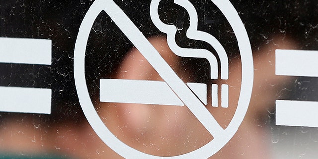 June 26, 2012: A student waits for a bus behind a no smoking sign at the State University of New York at Albany in Albany, N.Y. As tobacco bans are sweeping campuses nationwide, one California city has passed an ordinance requiring all apartments and condo units to be designated either smoking or non-smoking. (AP)