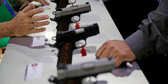 Guns sit on display at the NRA annual convention where President Donald Trump is scheduled to speak later in the day in Atlanta, Friday, April 28, 2017. (AP Photo/David Goldman)