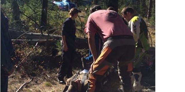 Photo shows rescuers escorting injured John Sain to helicopter in Idaho woods.(Jennifer Sain)