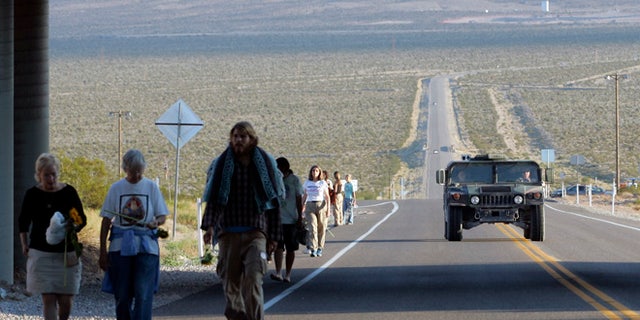 A U.S. Air Force humvee is driven past as anti-nuclear activists walk after a sunrise ceremony just outside the Nevada test site near Mercury, Nevada, 60 miles north of Las Vegas.