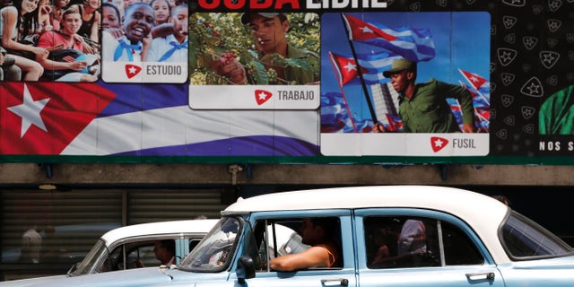 Un auto clásico estadounidense pasa frente a carteles que dicen "Viva Cuba libre" en La Habana, Cuba, el martes 16 de junio de 2015. El miércoles se cumplen seis meses desde que los presidentes Barack Obama y Raúl Castro sorprendieron al mundo al anunciar el fin de medio siglo de hostilidades entre Estados Unidos y Cuba. En Cuba, los envejecidos líderes temen un cambio rápido e incontrolado que les cueste el poder y pueda provocar inestabilidad en un país que teme a la violencia y la desigualdad que afectan a sus vecinos. Ese temor se ve acrecentado por la larga historia de intentos estadounidenses de derrocar a Castro y a su hermano Fidel. (AP Foto/Desmond Boylan)