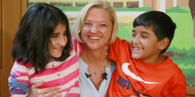 March 27, 2015: Lynette Austin, known as "Captain Sam," poses with war victims, Shah Bibi Tarakhail, left, and Abdul Wahid, during a media event at Shriners Hospitals for Children in Los Angeles.