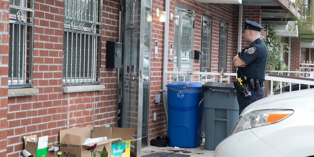 A police officer stands guard at a house where five people were stabbed.