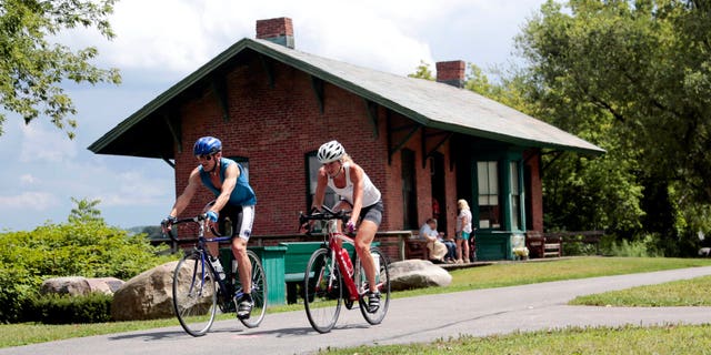 Cyclists pass the Niskayuna Train Station as they bike on the Canalway Trail in Niskayuna, N.Y. (AP Photo/Mike Groll, File)