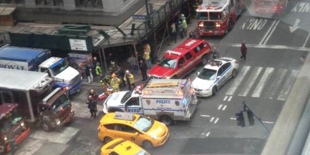 In this photo provided by Kaitlyn Ford, emergency personnel work the scene where authorities said four construction workers suffered serious injuries in a partial wall collapse inside a commercial building near Grand Central Terminal, in New York.