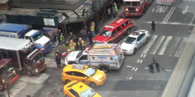 In this photo provided by Kaitlyn Ford, emergency personnel work the scene where authorities said four construction workers suffered serious injuries in a partial wall collapse inside a commercial building near Grand Central Terminal, in New York.