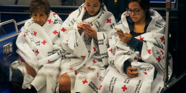 People gather on a city bus after fleeing from a fire in New York City.