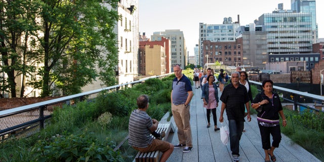 Pedestrians walks along High Line park in New York City