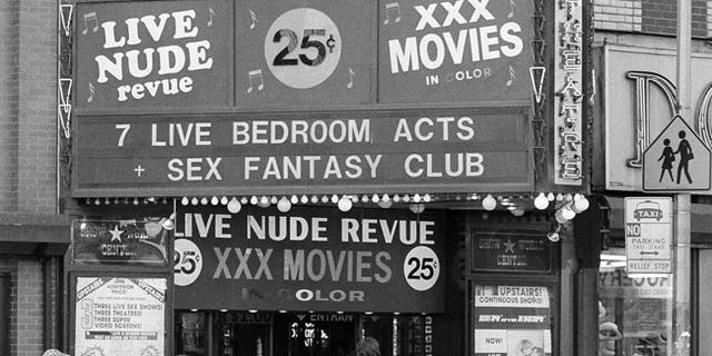 FILE - In this Aug. 9, 1979, file photo, people walk past Show World Center at the edge of New York's Times Square. New York City's two-decade legal war on storefront pornography businesses has reached a new tipping point. While many of the provocative attractions were swept out years ago, Show World Center is one of the last to survive. But the state's highest court recently issued a ruling that would force any remaining X-rated businesses to clear out. (AP Photo/G. Paul Burnett, File)