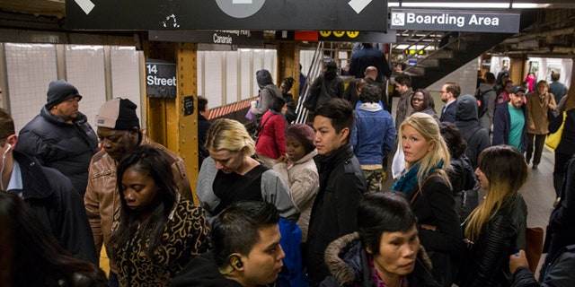 FILE Commuters depart an L train during the morning commute.