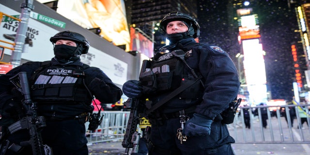 New York City Police Emergency Service Unit officers stand on guard in Times Square during New Year's Eve celebrations, Dec. 31, 2017.