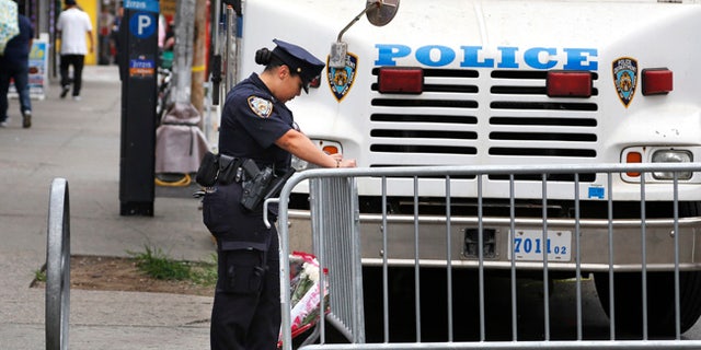 A police officer works near the site where an officer was killed in the Bronx section of New York, Thursday, July 6, 2017. Police officer Miosotis Familia was shot to death early Wednesday, ambushed inside her command post by an ex-convict, authorities said. He was later killed after pulling a gun on police. (AP Photo/Seth Wenig)