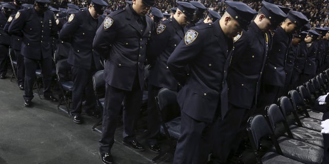 Dec. 29, 2015- Newly inducted New York Police officers observe a solemn moment at a graduation ceremony at Madison Square Garden. (REUTERS)