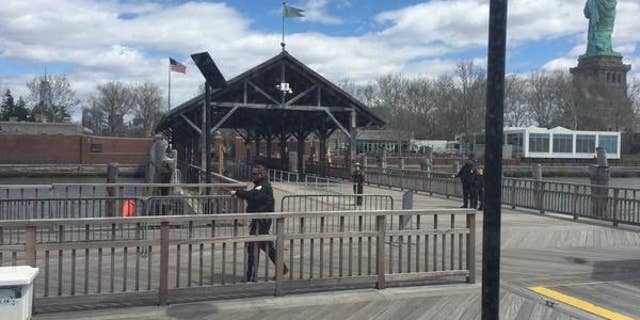 This photo, taken by tourist Rick Borgmeyer, of St. Louis, Mo., shows New York City Police officers inspecting the perimeter of Liberty Island Friday after reports of a suspicious package.