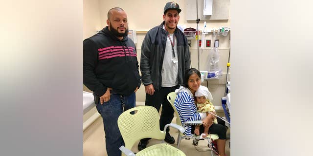 NYPD officers Felix Baez and Giovanni Laguna stand with Lilina Benigno and her daughter, Ashley Dolores.