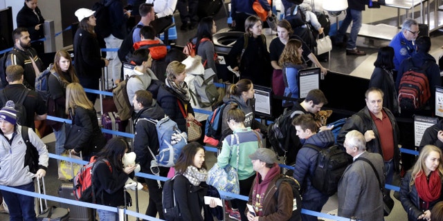 Travelers queue at a security checkpoint at O'Hare International Airport.