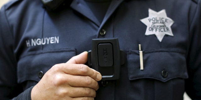 File photo - Oakland Police Department officer Huy Nguyen mounts a Portable Digital Recording Device, a body camera designed to record both audio and video in the field, at the police headquarters in Oakland, California April 14, 2015. (REUTERS/Robert Galbraith)