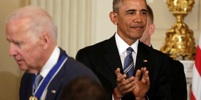 U.S. President Barack Obama (R) applauds after presenting the Presidential Medal of Freedom to Vice President Joe Biden in the State Dining Room of the White House in Washington, U.S., January 12, 2017. REUTERS/Yuri Gripas - RTX2YQ15