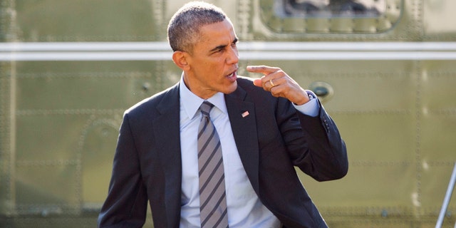 Nov. 21, 2014: President Barack Obama signals to his aides and staff that he will return to the White House because he forgot something before his departure on Marine One helicopter