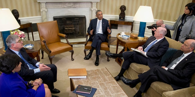 FILE - In this Feb. 17, 2016, file photo, President Barack Obama, joined by from left, Commerce Secretary Penny Pritzker, former IBM CEO Sam Palmisano, former National Security Adviser Tom Donilon, and Homeland Security Secretary Jeh Johnson, talks to media in the Oval Office of the White House, in Washington.