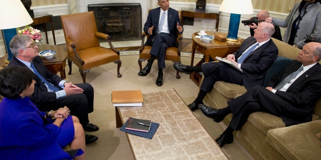 FILE - In this Feb. 17, 2016, file photo, President Barack Obama, joined by from left, Commerce Secretary Penny Pritzker, former IBM CEO Sam Palmisano, former National Security Adviser Tom Donilon, and Homeland Security Secretary Jeh Johnson, talks to media in the Oval Office of the White House, in Washington.