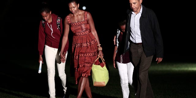 President Obama, first lady Michelle Obama and their daughters Sasha and Malia, far left, walk across the South Lawn of the White House in Washington, Friday, Aug., 26, 2011, after a family vacation on Martha's Vineyard.