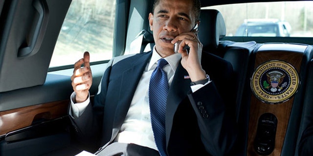 President Barack Obama speaks on an unidentified flip phone in the presidential limousine in northern Virginia in March 2010.