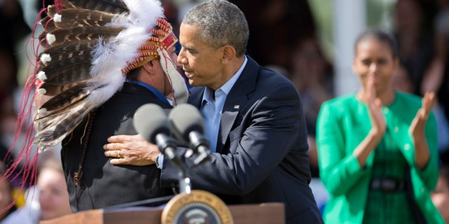 June 13, 2014: President Obama embraces Standing Rock Sioux Tribal Nation Chairman Dave Archambault II as first lady Michelle Obama watches in Cannon Ball, N.D.