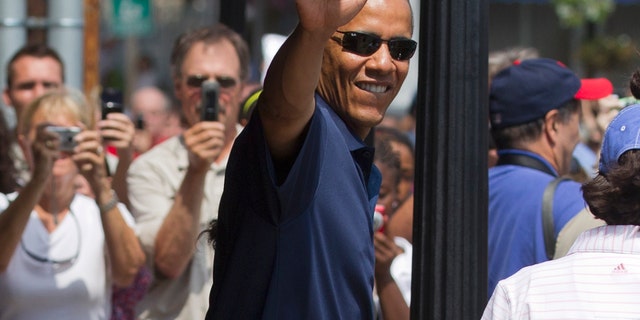 President Barack Obama, with his daughters Malia Obama and Sasha Obama, not seen, waves as they leave the Bunch of Grapes book store in Vineyard Haven, Mass., Friday, Aug. 19, 2011, during a family vacation. (AP Photo/Carolyn Kaster)