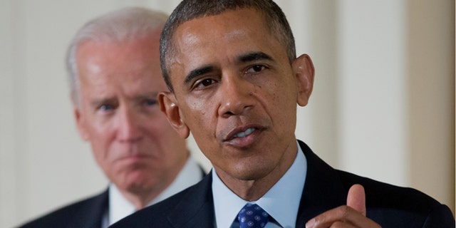 Jan. 22, 2014: Vice President Joe Biden listens as President Barack Obama speaks in the East Room of the White House in Washington.