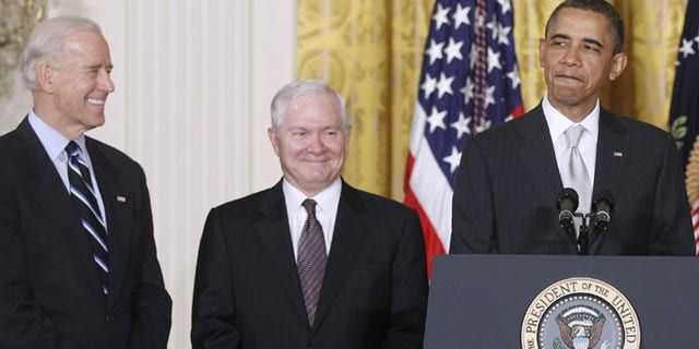 In this April 28. 2011 file photo, President Obama stands in the East Room of the White House in Washington with Vice President Biden and then-outgoing Defense Secretary Robert Gates.