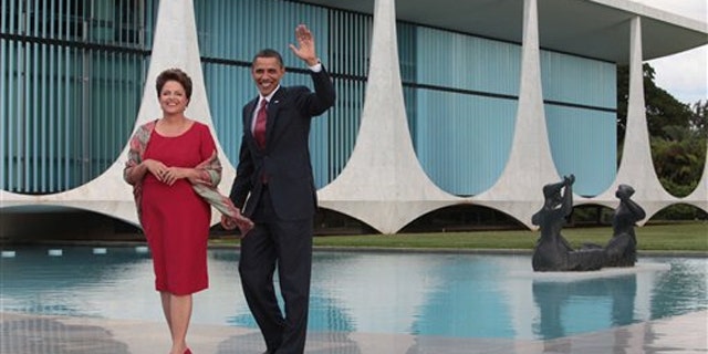 Saturday: President Obama, accompanied by Brazil's President Dilma Rousseff, waves as he arrives in Brasilia, Brazil.