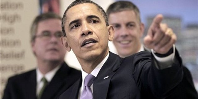 President Obama points as he tours classrooms at Miami Central Senior High School with Education Secretary Arne Duncan, right, and former Florida Gov. Jeb Bush March 4 in Miami.