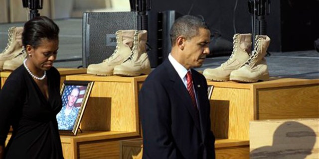 President Obama and first lady Michelle Obama walk past a memorial for victims of the Fort Hood shooting Nov. 10 at Fort Hood, Texas. (AP Photo)