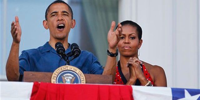 President Obama with first lady Michelle Obama, right, delivers his remarks from the White House's Blue Room balcony for an Independence Day celebration July 4 in Washington. (AP Photo)