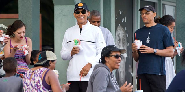 Jan. 1, 2015: President Obama smiles as he eats shave ice with friends and his daughters in Kailua, Hawaii.