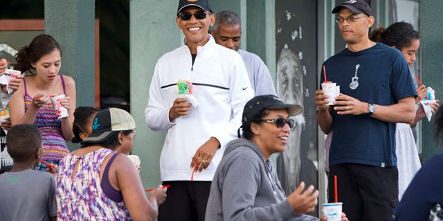 Jan. 1, 2015: President Obama smiles as he eats shave ice with friends and his daughters in Kailua, Hawaii.