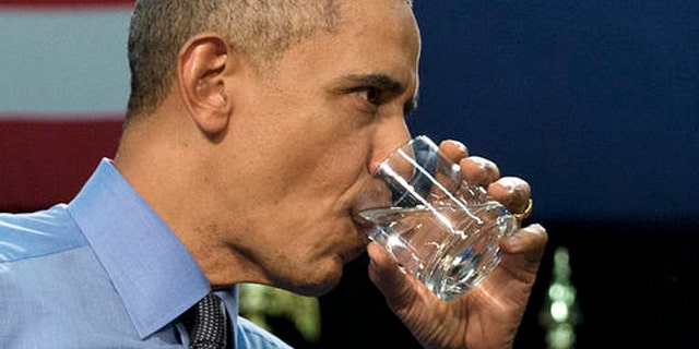 President Barack Obama drinks water as he finishes speaking at Flint Northwestern High School in Flint, Mich., Wednesday, May 4, 2016, about the ongoing water crisis.