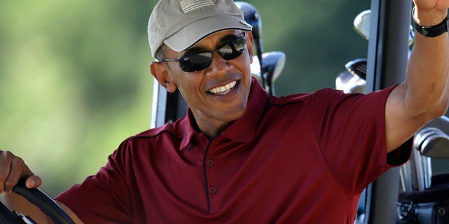Aug. 14, 2015: President Barack Obama waves from a golf cart while golfing at Farm Neck Golf Club, in Oak Bluffs, Mass., on the island of Martha's Vineyard.