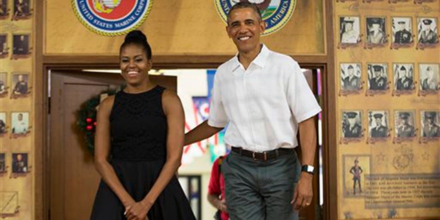 First lady Michelle Obama, left, and President Barack Obama arrive for an event to thank service members and their families at Marine Corp Base Hawaii, on Friday, Dec. 25, 2015, in Kaneohe Bay, Hawaii. (AP Photo/Evan Vucci)
