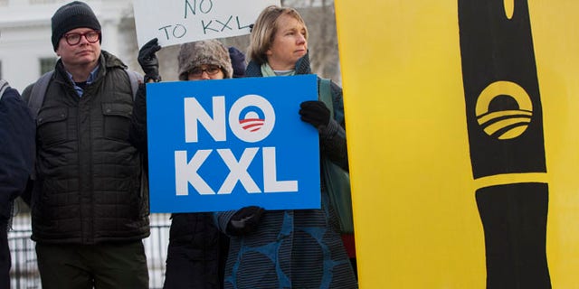 Feb. 24, 2015: Melinda Pierce, center, with the Sierra Club, holds a "No KXL" sign, next to a large poster of a pen as she gathers with other opponents of Keystone XL oil pipeline to celebrate President Barack Obama's veto of the legislation outside the White House in Washington. (AP)