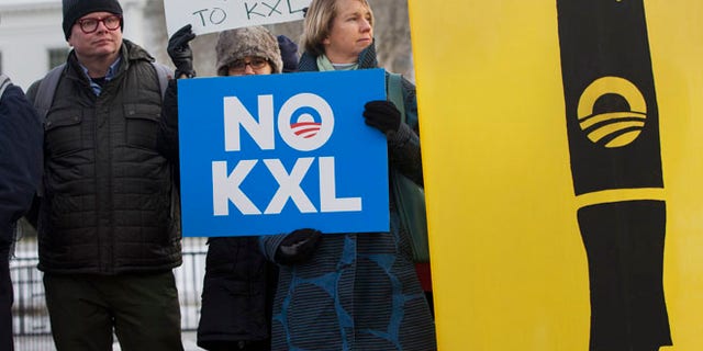Feb. 24, 2015: Melinda Pierce, center, with the Sierra Club, holds a "No KXL" sign, next to a large poster of a pen as she gathers with other opponents of Keystone XL oil pipeline to celebrate President Barack Obama's veto of the legislation outside the White House in Washington. (AP)
