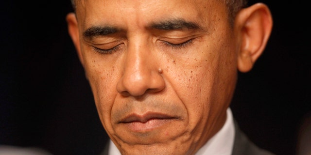 Feb. 6, 2014: President Barack Obama closes his eyes as a prayer is offered at the National Prayer Breakfast in Washington. The president told the non-denominational gathering of political leaders that freedom of religion across the world is important to national security and is a central tenet of U.S. diplomacy. (AP/Charles Dharapak)